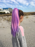 Girl wearing pink & purple hair extension on the beach
