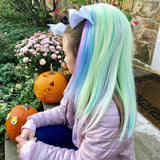 Girl wearing purple hair extensions blue hair extensions yellow hair extensions pink hair extensions for girls sitting next to pumpkins