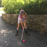 Girl playing field hockey with her matching pink and teal hair extension